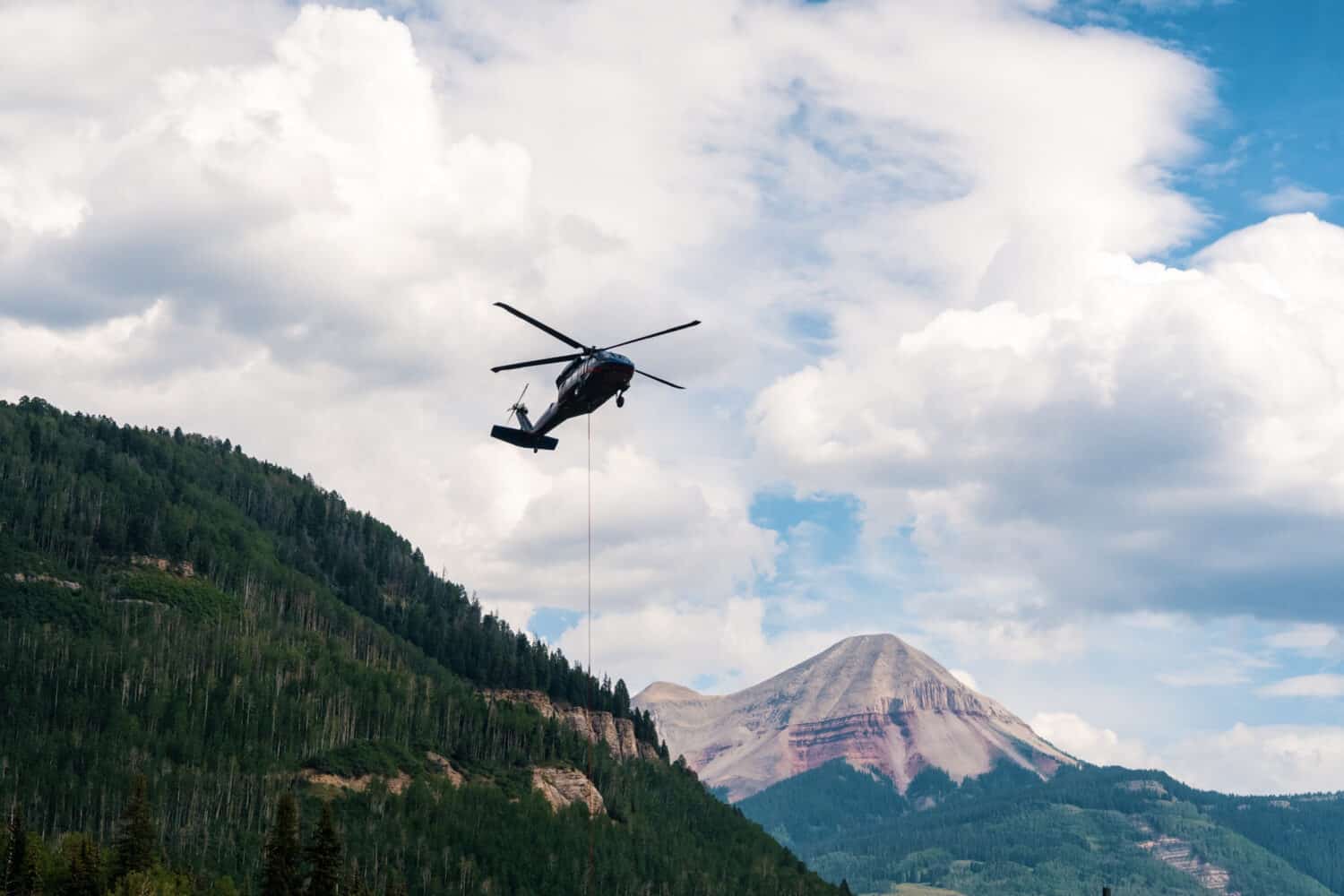 Helicopter transports forms and concrete to the lift tower locations of the new lift at Purgatory resort, newly named the Colorado Couloir