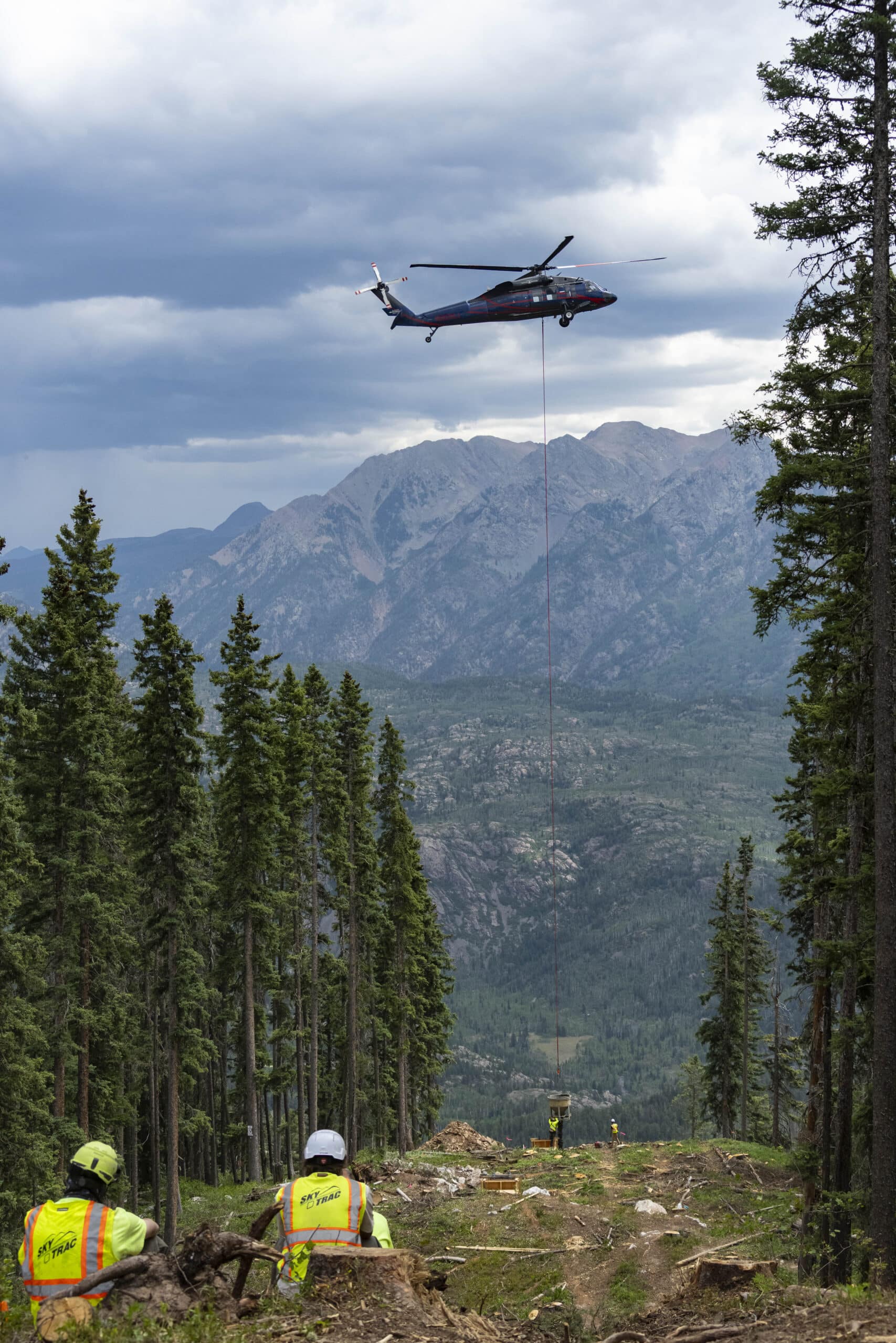Helicopter delivers a load of cement to pour in the tower forms on the Colorado Couloir lift install